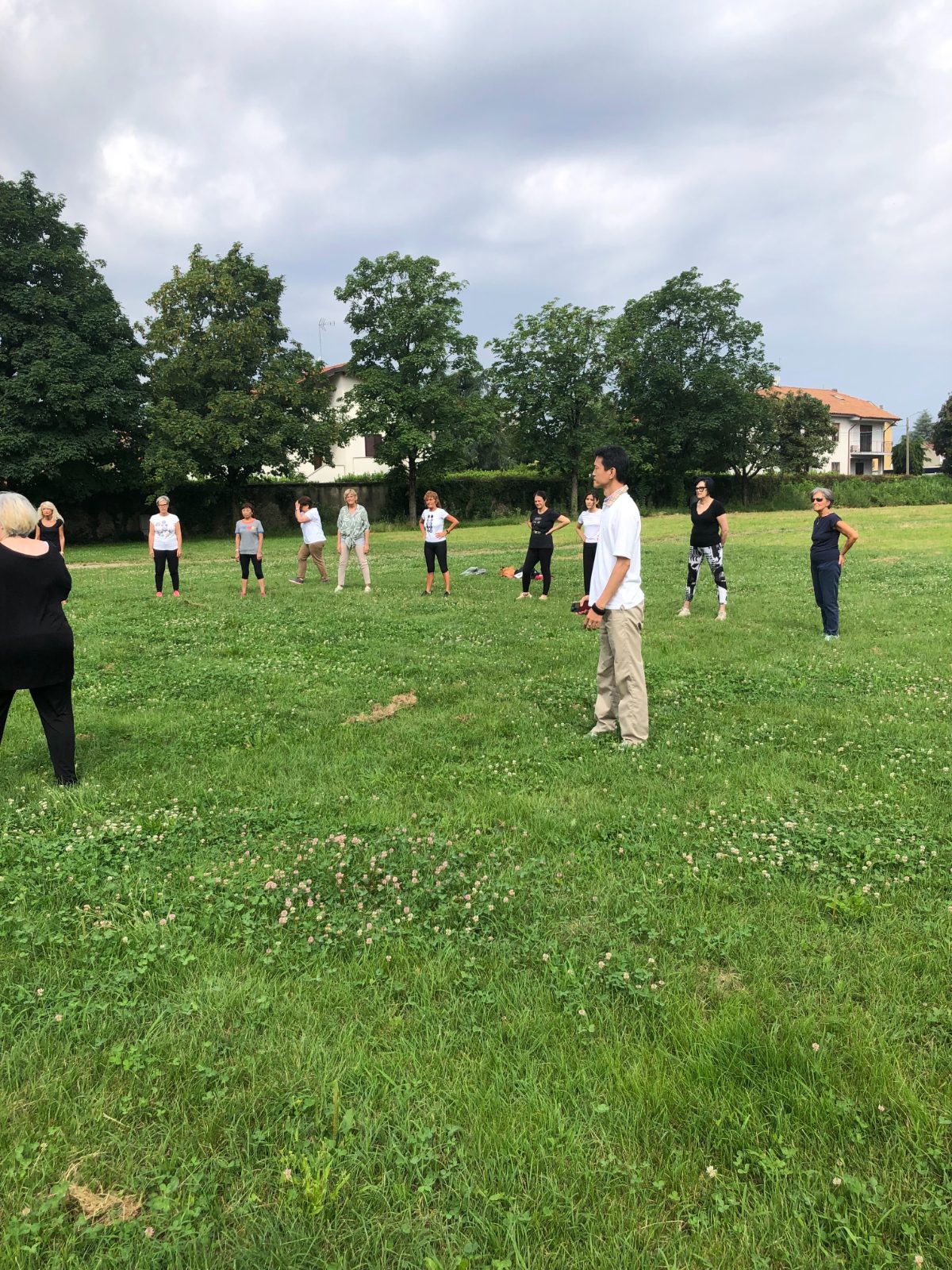 Master Lo and Italian students lined up on the grass in a group qigong class